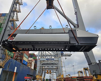 Image of the large screw pumps being loaded onto a shipping ship