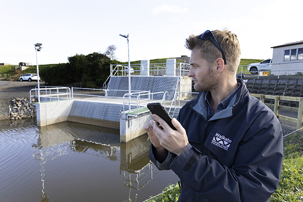 Image of a pump station with a council staff worker in the foreground