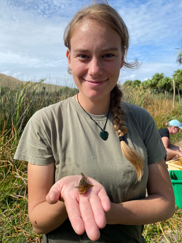 Woman wearing t-shirt and holding hand out-stretched with an invertebrate 